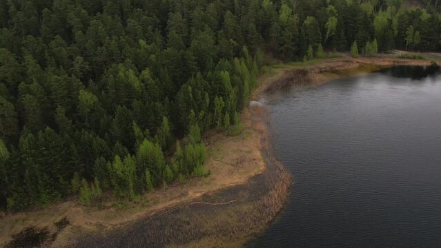 Bird's eye view of the lake in the forest. It's cloudy outside. Hiking trip