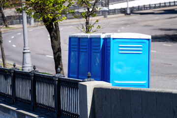 A line of portable plastic toilets on the sidewalk