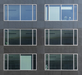 abstract image of windows in a dark stone facade of a building