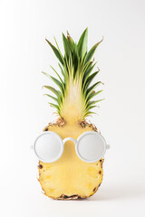 Sliced pineapple with white sunglasses on white background. Creative minimal summer concept.