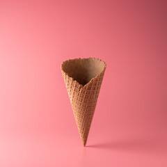 Ice cream cone on pink background. Minimal summer concept.