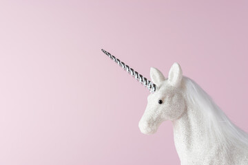 Creative composition with glitter unicorn on pink background. Minimal holiday concept.