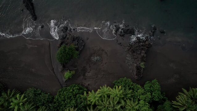 Waves arriving in a idyllic beach with dark sand