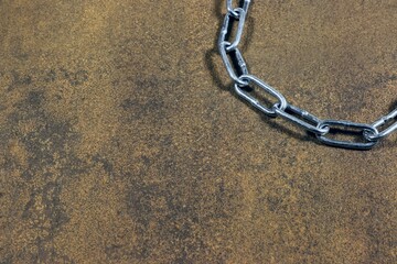 A section of shiny metal chain in the corner of the frame.