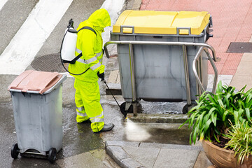cleaning and disinfection in city street by professional worker with protective suit and masks  to...