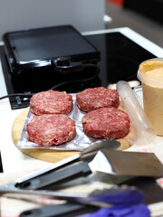 carne cruda para hamburguesas en la cocina junto a la freidora a la plancha