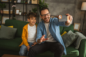 Father and son make a self portrait at living room