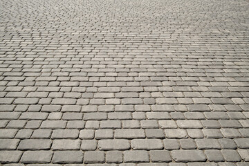 Stone pavement texture in perspective. Abstract background of old cobblestone pavement.