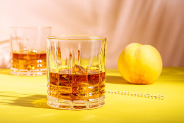 Rum or Amaretto sour with ice in a glass on a bright background. Summer party concept.