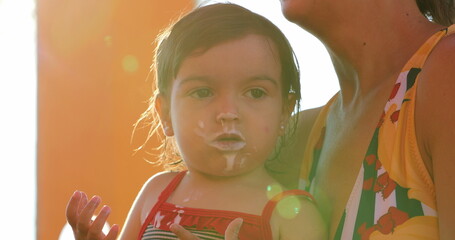 Little girl mouth covered with yogurt