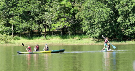 Kids kayaking outside at lake inside canoe