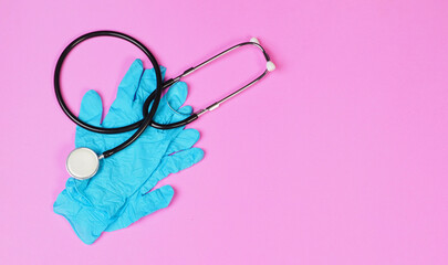 Stethoscope and Blue latex gloves on pink background