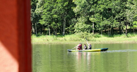 Kids kayaking outside at lake inside canoe