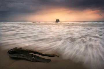 Sunset on Atxabiribil beach, Sopelana, Bizkaia, with a truck dragged by the tide and a dramatic sky...