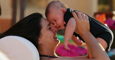 Mother and baby interaction by the poolside during summer vacations