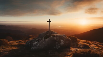 Silhouette of a cross on a mountain at sunset