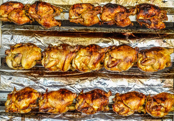 Grilled chickens in spinning rolls at a farmers market in France
