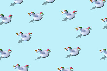 Creative pattern with inflatable unicorn pool toy on blue background. Minimal summer concept.