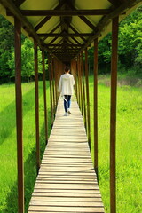 A person walking on a wooden bridge