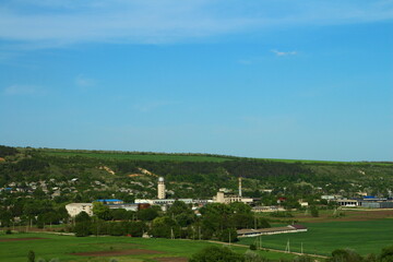 Obraz premium A green field with a factory in the distance