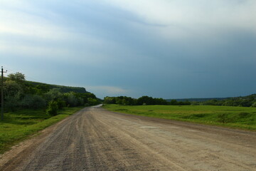 A road with grass and trees on the side