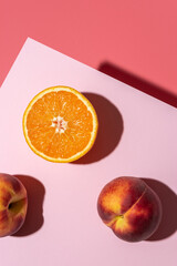 Orange fruit with peaches on bright background. Minimal food concept.