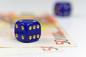 Blue dice and euro banknotes on white background