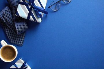 Flat lay composition with gift boxes, coffee cup, tie, glasses on dark blue background. Happy...