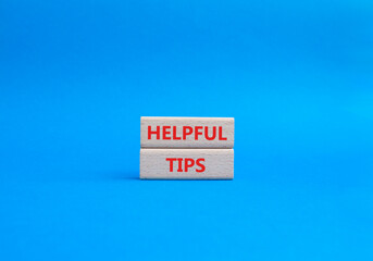 Helpful tips symbol. Wooden blocks with words Helpful tips. Beautiful blue background. Business and...