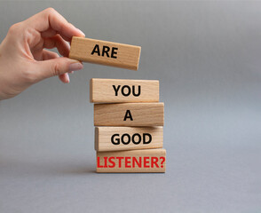 Listening skills symbol. Wooden blocks with words Are you a good Listener. Beautiful grey background. Businessman hand. Business and Are you a good Listener concept. Copy space.
