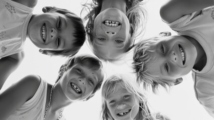 Group of kids looking down at a camera laughing happily
