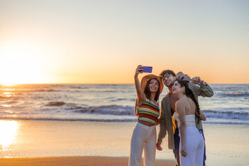 copyspace Multicultural Latin friends take a selfie on beach shore during summer sunset