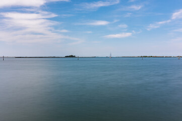 Fototapeta premium Panorama of the sky and sea in Grado, Italy with long exposure sunny day, view of the rocks.