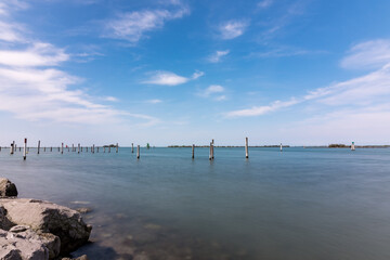 Obraz premium Panorama of the sky and sea in Grado, Italy with long exposure sunny day, view of the rocks.