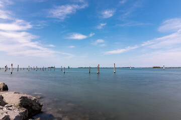Panorama of the sky and sea in Grado, Italy with long exposure sunny day, view of the rocks.