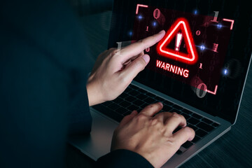Warning sign alert on laptop screen. System hack, cybersecurity, cyber attack, phishing scams.
