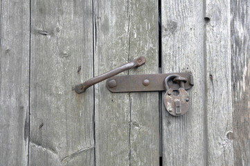Old lock on the door. Locking device of an old farmhouse. Background.