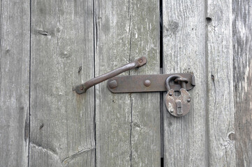 Old lock on the door. Locking device of an old farmhouse. Background.