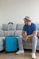 Happy man with suitcase prepared about to go on vacation