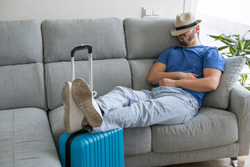 Man resting on the sofa with travel suitcases prepared