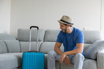 Happy man with suitcase prepared about to go on vacation