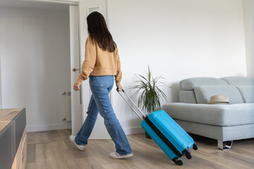 Women leaving home with travel suitcase