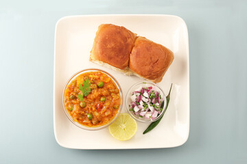 Pav Bhaji is a fast food dish from India, Thick and spicy vegetable curry, fried and served with a soft bread roll/Bun Pav and butter