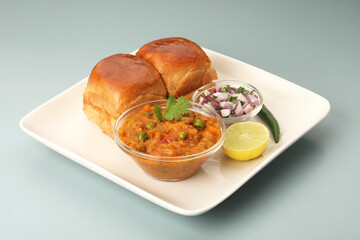 Pav Bhaji is a fast food dish from India, Thick and spicy vegetable curry, fried and served with a soft bread roll/Bun Pav and butter