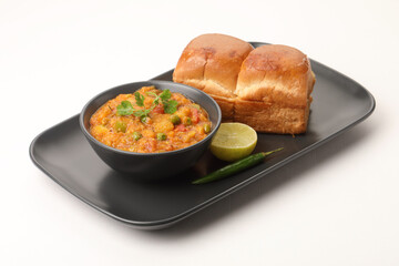 Pav Bhaji is a fast food dish from India, Thick and spicy vegetable curry, fried and served with a soft bread roll/Bun Pav and butter