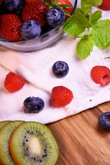 Fresh strawberries and blueberries in a glass bowl.