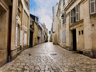 Cobblestone street with medieval houses in old city of Orleans