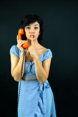 Young Woman Talking on Orange Retro Phone. Vintage Girl Talking Pin Up Phone. woman making hush sign