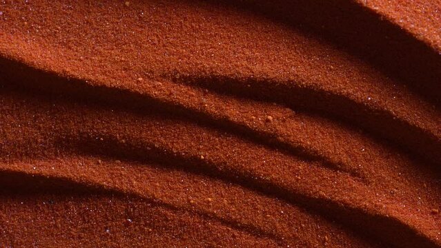 Small bright orange crystals of potassium dichromate, close up, abstract colorful background, rotates