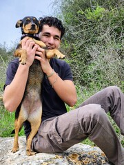 Young man with a dog in the nature. The concept of friendship between people and animals.